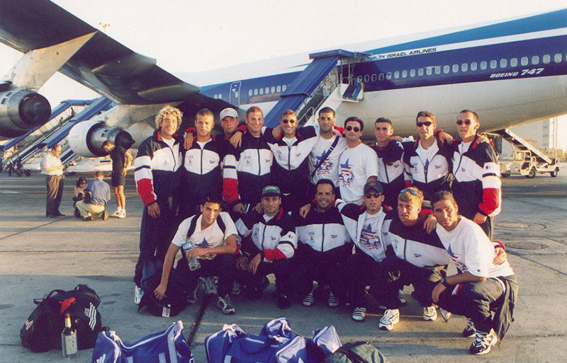 group of male athletes on the tarmac in front of an airplane