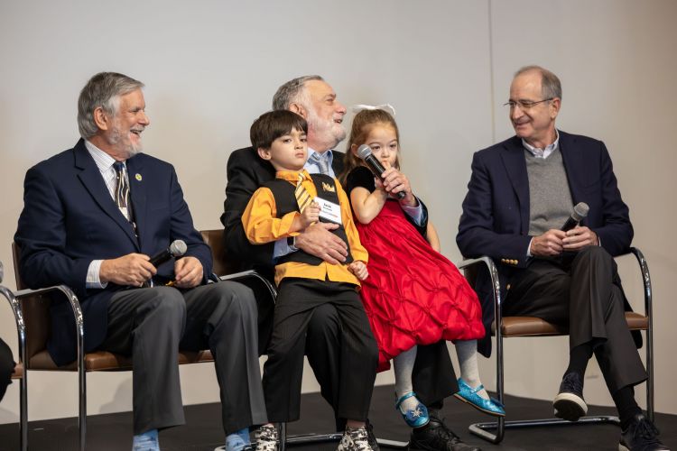 Lou Moyerman with grandkids on stage laughs with Brian Roberts