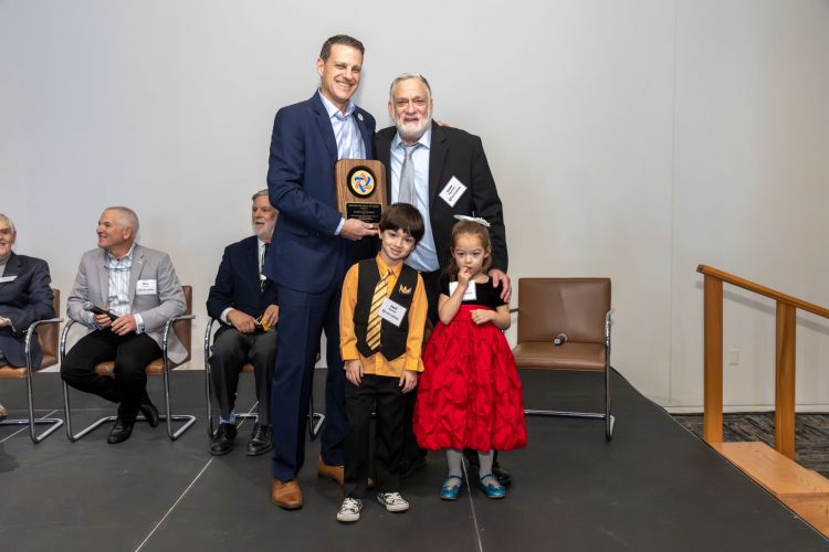 Marshall Einhorn gives MOH plaque to Lou Moyerman and grandkids