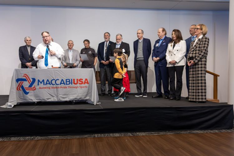 Rabbi Monson lights candles with honorees behind
