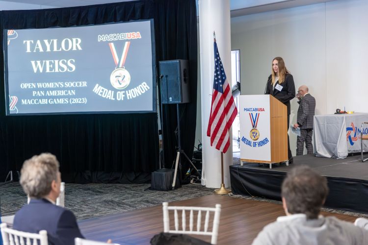 Taylor Weiss speaks at podium