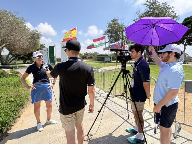 Jake Baum interviews female golfer with Devin Chernin Eliot Pototsky on camera and umbrella IMG_7328
